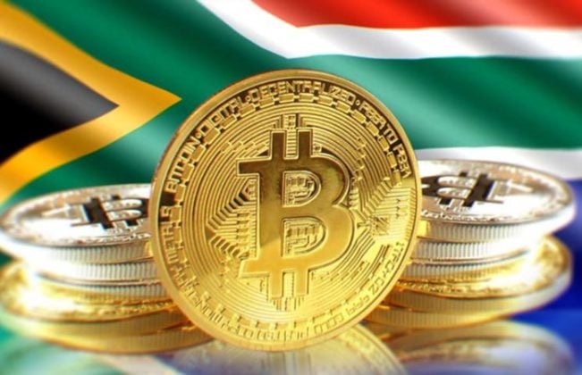 Bitcoin (BTC) is illustrated as stcak of physical gold coins with the national flag of South Africa on the background