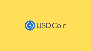 The logo of USDC with the colour of yellow on the background